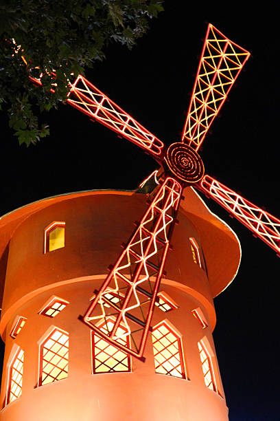 Famous Red "Paris, France - June 27, 2012: The famous red windmill of the Moulin Rouge in the Pigalle district of Paris, at night." place pigalle stock pictures, royalty-free photos & images