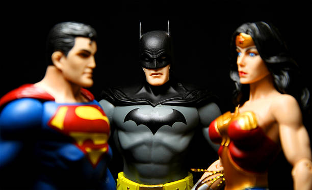 Threesome "Vancouver, Canada - October 9, 2012: Action figure models of Wonder Woman and Superman with Batman in the middle, released by DC comics, against a black background." superman named work stock pictures, royalty-free photos & images