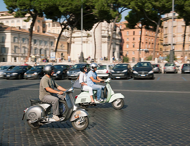 Rome, Italy - September 23, 2011: Motion blur in the background as people ride scooters on a cobbled street in central Rome.