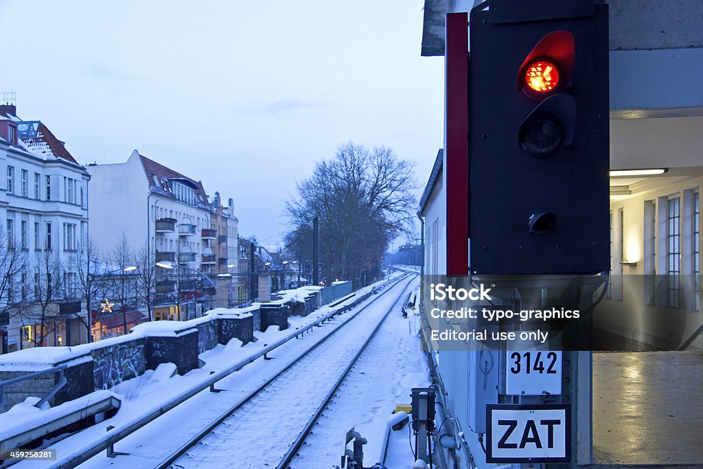 The train is not coming "Potsdam, Germany - December 14, 2012: The train is not coming, twilight scene. View form the train station in Potsdam-Babelsberg to snow-covered railroad track (in the direction to Berlin). In winter the Berlin S-Bahn has often difficulties to drive because of snow, ice and broken switches. As a consequence are delays. On the left sight are seen some buildings of Potsdam-Babelsberg, in foreground is seen a red Stop sign (traffic light at the railroad track)." Shunting Yard Stock Photo