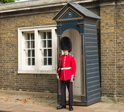 London, UK - September 29, 2012: A Coldstream Guard soldier standing guard near Buckingham Palace in the City of Westminster, central London.