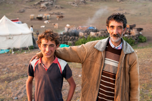 Igdır,  Turkey - July 18, 2008 :Kurdish man and his son posed front of their tent. High in the mountains in the border between Turkey and Armenia.