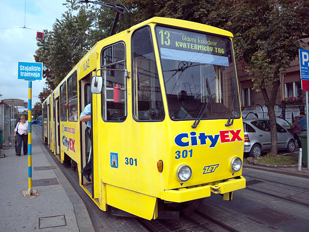 Zagreb, Croatia - September 09, 2013 : man is getting on to the tram in Zagreb. The woman is passing the tram stop.