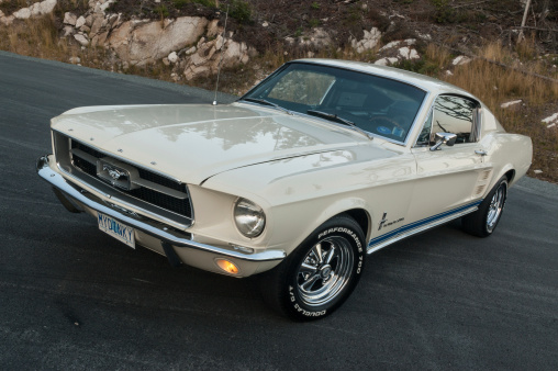 Buenos Aires, Argentina - Jun 4, 2023: Shot of a black and blue sport muscle car 1960s Ford Mustang coupe in a parking lot.