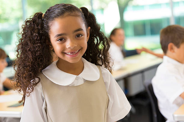 istock Cute kindergarten age child in classroom wearing private school uniform 459262629
