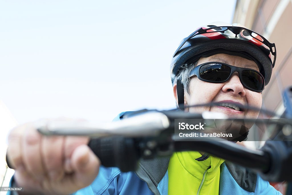 Senior donna in bicicletta - Foto stock royalty-free di Ambientazione esterna