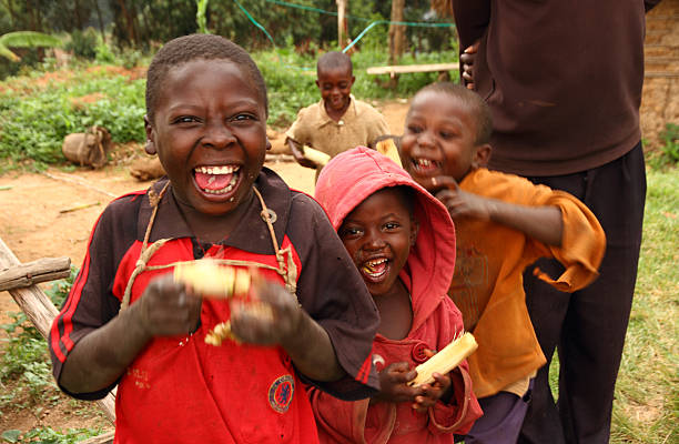 Lake Bunyoni, Uganda - September 26, 2012.  A group of Ugandan children smile while enjoying eating sugarcane near Lake Bunyoni, Uganda during September 2012.