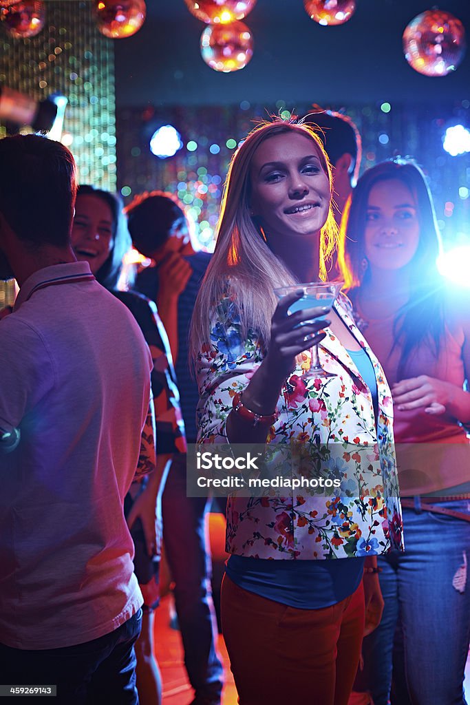 Party time Beautiful girl drinking cocktail on crowded dance floor 20-29 Years Stock Photo