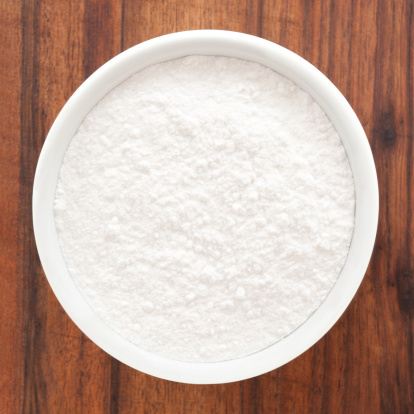 Top view of white bowl full of powder sugar