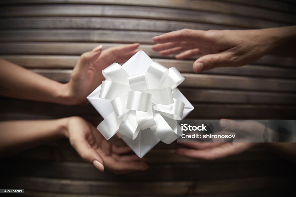 Giving Christmas present Image of female hands giving Christmas present to her friend Celebration Stock Photo