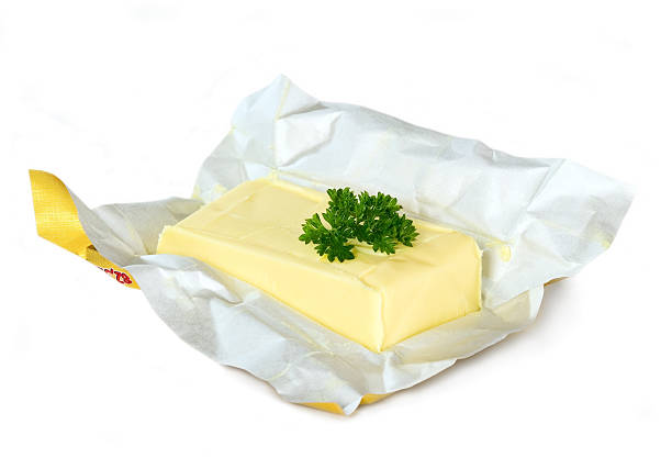 Yellow butter with paper package Yellow butter with paper package placed on isolated background butter margarine isolated portion stock pictures, royalty-free photos & images