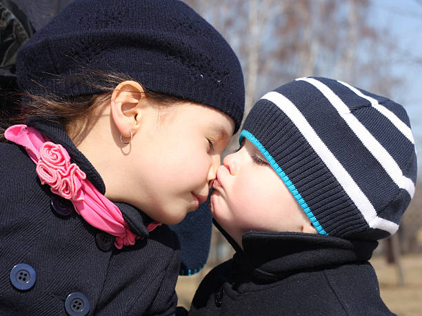 menino kisses irmã - stealing a kiss imagens e fotografias de stock