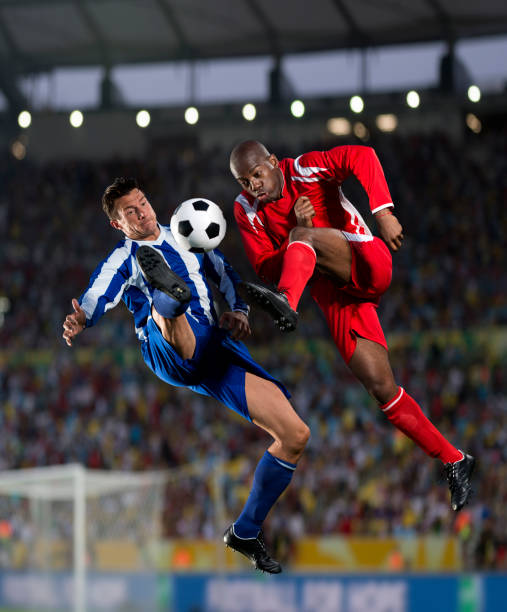 Free Stock Photo of Two footballers are fighting for the ball on the  football field