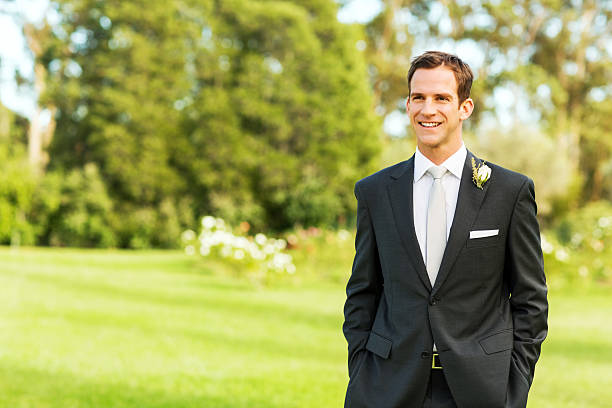 istock Groom Looking Away While Standing With Hands In Garden 459293163