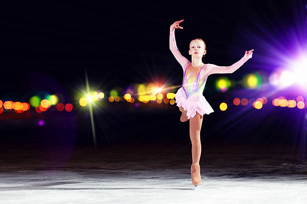 istock Young girl figure skating on ice with blurred lights in back 459293199