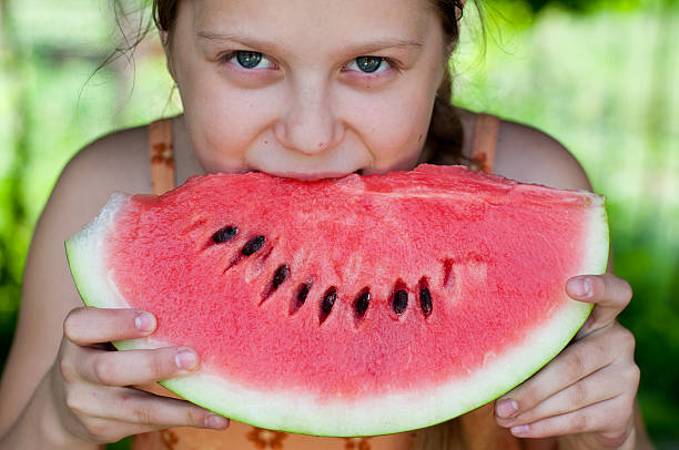 istock girl eating fresh watermelon 459298521