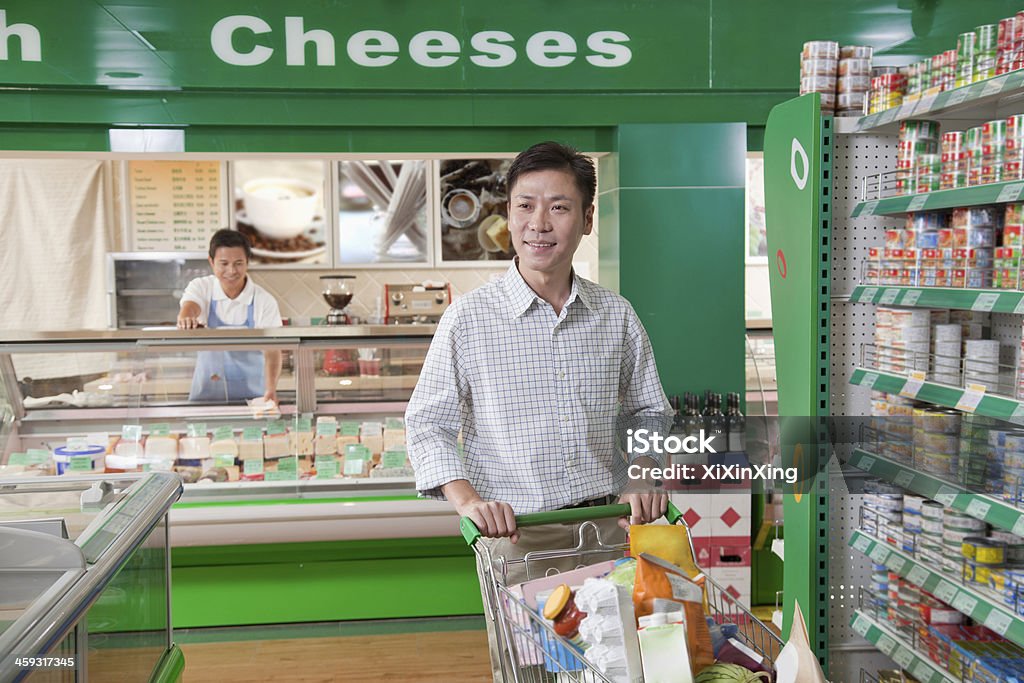 Man shopping in supermarket, pushing cart, Beijing Pushing Stock Photo