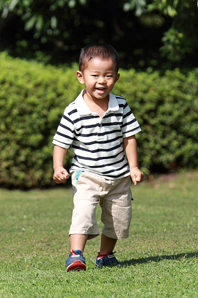 istock Japanese boy running on the grass 459325473