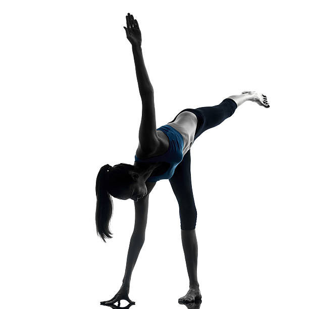 istock woman exercising yoga warrior position silhouette 459327325