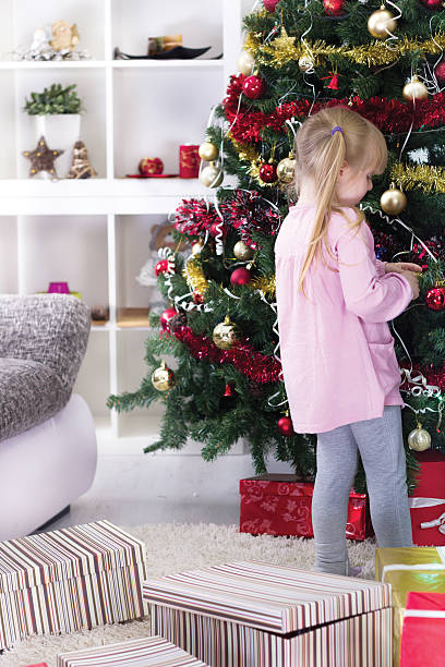 istock little girl at home decorating the Christmas tree 459329485