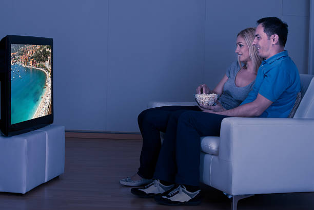 istock Happy Couple Eating Popcorn And Watching Television 459330541