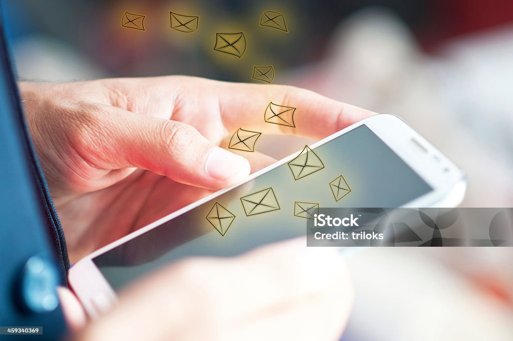 Man using a phone to send and receive emails Sending and receiving emails E-Mail Stock Photo