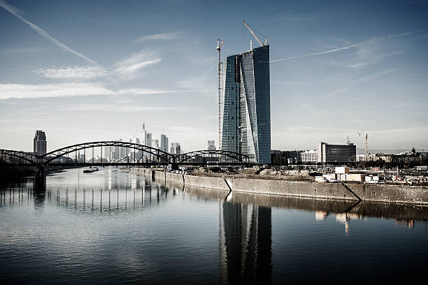 Frankfurt, Germany- November 23, 2014: Tower of the new European Central Bank. It is the headquarters of ECB under construction in Frankfurt, Germany. The 500 million euro project will be completed at winter 2014. In front you see a skate park. People are riding the scooter or watching there.