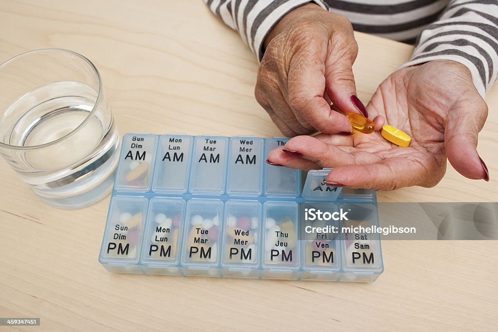 Taking Pills Elderly woman takes her medicine Medicine Stock Photo