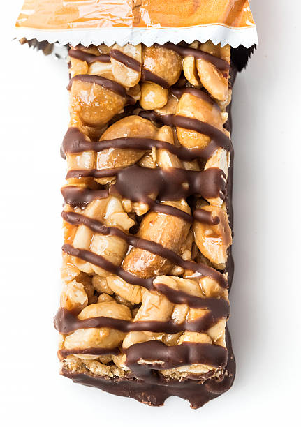 Chocolate and peanuts energy bar Chocolate and peanuts energy bar close up on white background chewy stock pictures, royalty-free photos & images