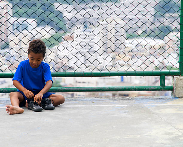 мальчик сидит, чтобы надеть эту обувь - day expressing positivity clothing desire стоковые фото и изображения