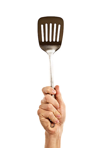 istock I can cook! Triumphant hand holds up egg turner 459360033