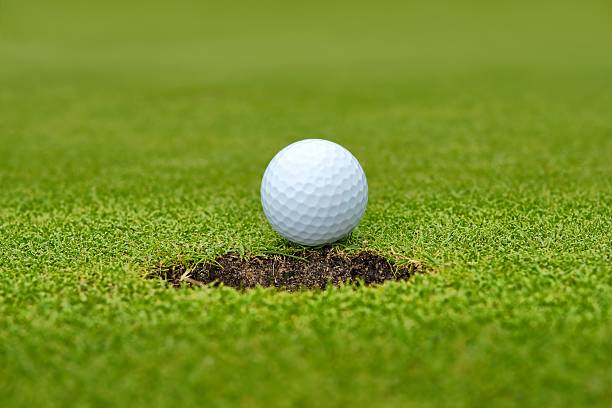 istock Golf, ball lying on the green next to hole 459362755