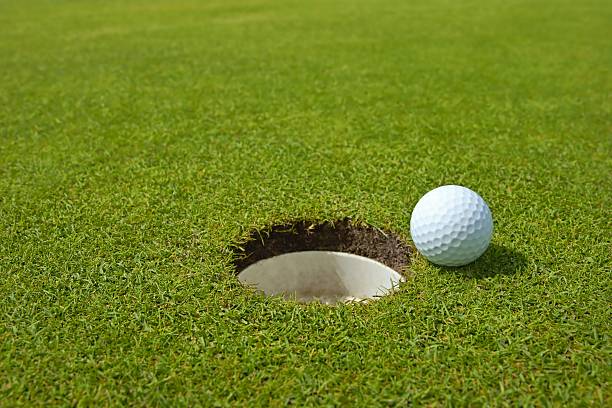 istock Golf, ball lying on the green next to hole 459362761
