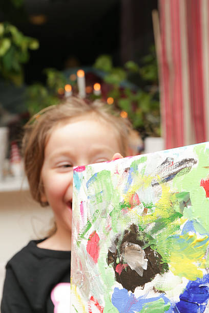 istock Girl holing up a canvas painting 459367399