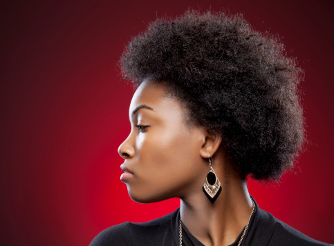 Black woman afro, portrait and confident face in beauty and style against a studio background. Beautiful isolated African American female proud model with necklace, jewelry and hairdo for fashion