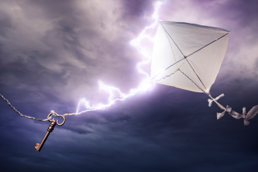 Conceptual image of kite with key being stuck by lightning