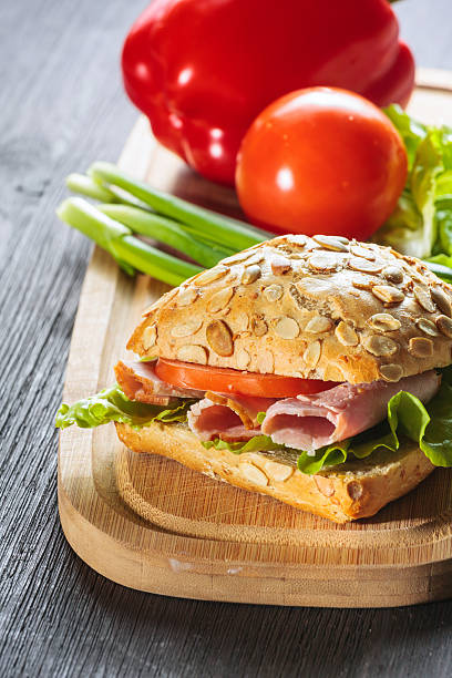 istock Fresh ham sandwich on wooden board - close up 459371139