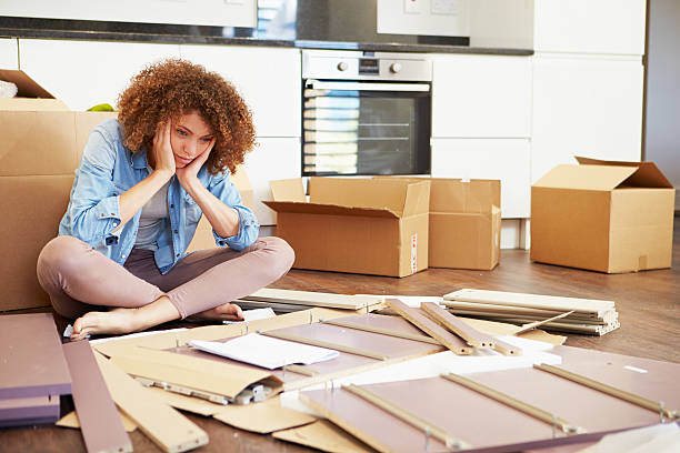 Woman cross legged in front of self assembly furniture Frustrated Woman Giving Up OnPutting Together Self Assembly Furniture model kit stock pictures, royalty-free photos & images
