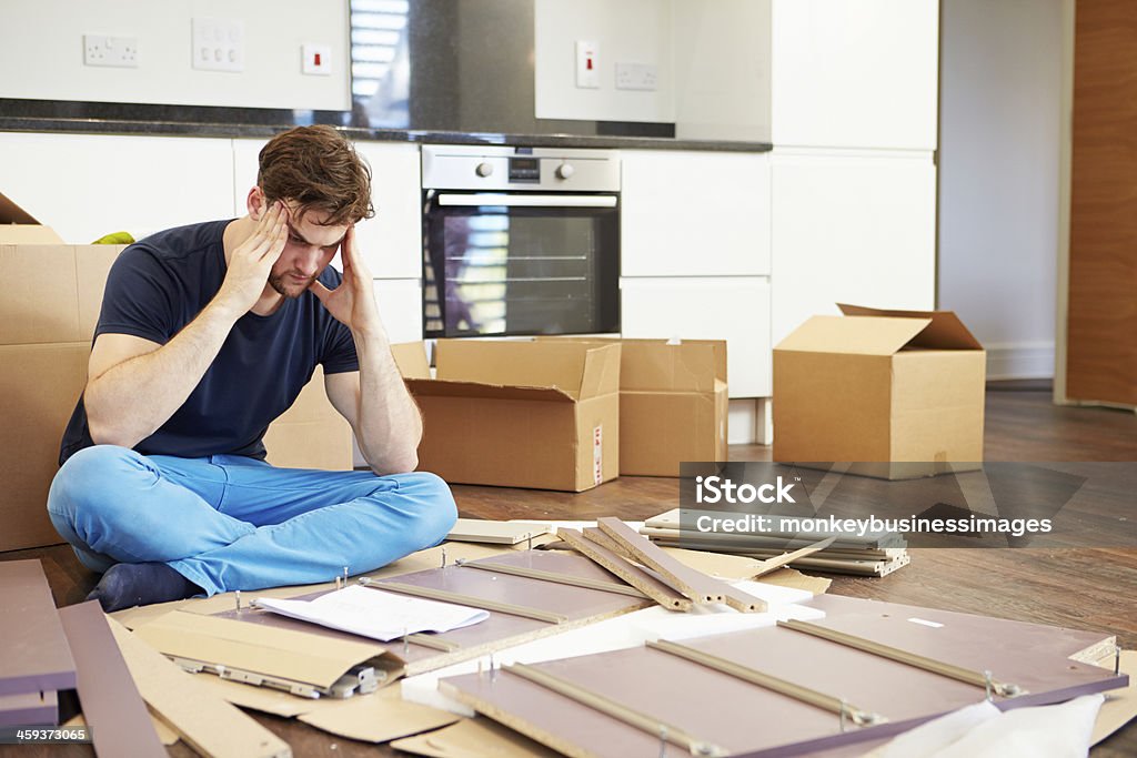 A man confused in putting together a self assembly furniture Frustrated Man Giving Up On Putting Together Self Assembly Furniture Furniture Stock Photo