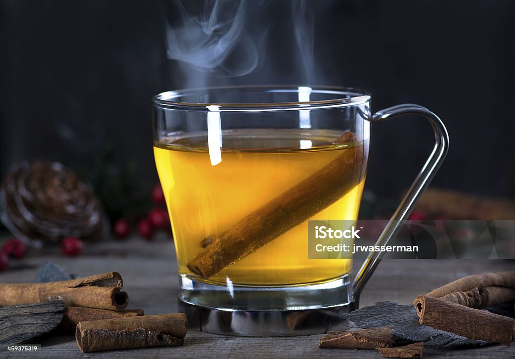 Hot Toddy Cocktail Drink with Cinnamon Hot  whisky, rum, apple or brandy toddy cocktail drink with cinnamon set on rustic wood Hot Apple Cider Stock Photo