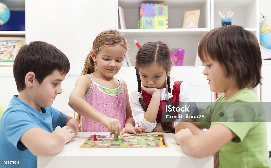 Children playing board game Children playing board game - sitting around a small table Child Stock Photo