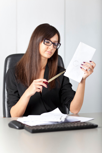 Portrait of woman secretary at work while open a letter