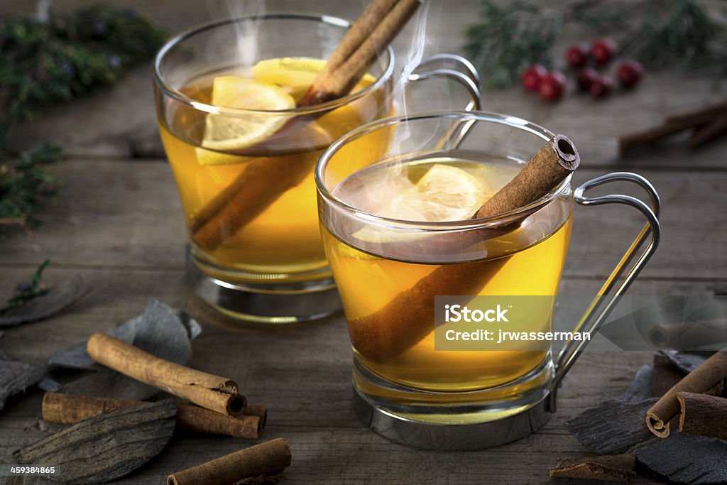 Two Hot Toddy Cocktail Drinks with Cinnamon and Lemmon Two hot  whisky, rum, apple or brandy toddy cocktail drinks with cinnamon set on rustic wood Hot Toddy Stock Photo