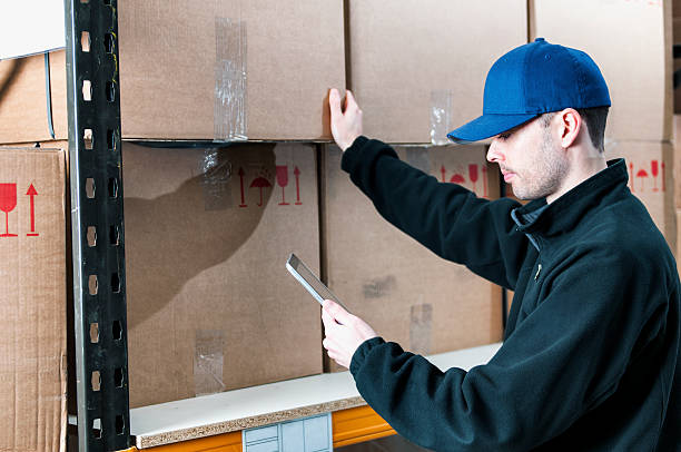 istock Worker in a warehouse holds tablet and check supply 459385537