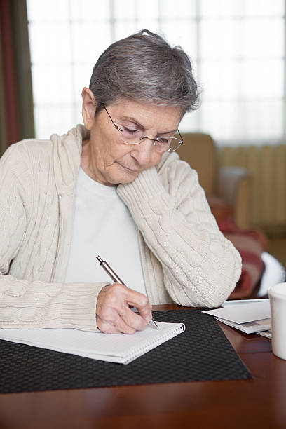 istock Senior Woman budgeting and paying bills 459386047