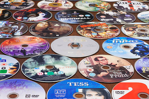 Many DVDs on a table - Background Durham, England - October 2, 2011: many DVDs, Region 1 and 2, from the British, American and Italian market, are arranged on a table, without their box. Titles in prominent position include: THE BLUES BROTHERS, TESS, THE FRONT, NO DEPOSIT NO RETURN, THE LORD OF THE RINGS, BRUBAKER, THE DOWNFALL, STAR WARS, THE THING paramount studios stock pictures, royalty-free photos & images