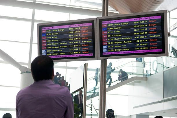 homme à la recherche de départ à repasser - airport india arrival departure board delhi photos et images de collection