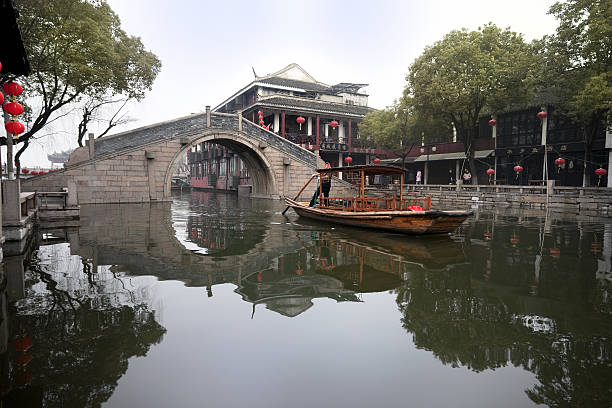 Ancient canal town of Zhouzhuang Zhouzhuang, China - February, 15th 2011:Zhouzhuang is located in Kunshan City, Jiangsu Province, China. Sampan boat is getting ready for tourist for a morning ride.  Zhouzhuang was built around 1,000 years ago, it is one of the most famous canal towns in China and attracts thoudsands of tourist daily. grand canal china stock pictures, royalty-free photos & images