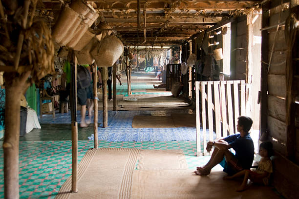 homem da tribo iban sentado na maloca. - iban tribe - fotografias e filmes do acervo