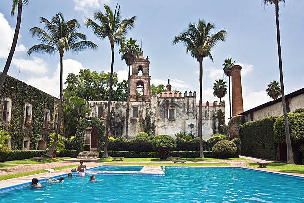 Swimming Pool Cuernavaca, Mexico - July 29, 2008: A Swimming Pool inside a colonial hacienda. The ruins of the hacienda have been rebuild to form a public pool and recreation area. cuernavaca stock pictures, royalty-free photos & images